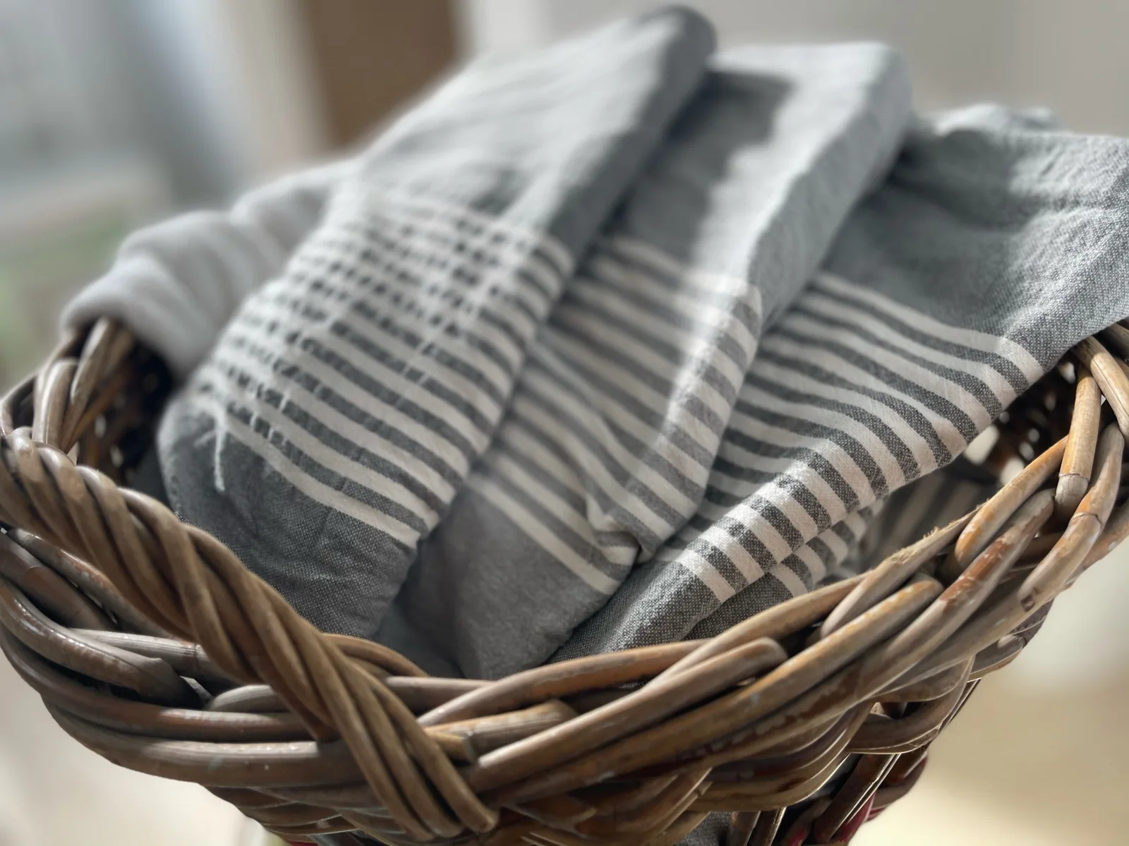 Wicker basket with folded striped textiles