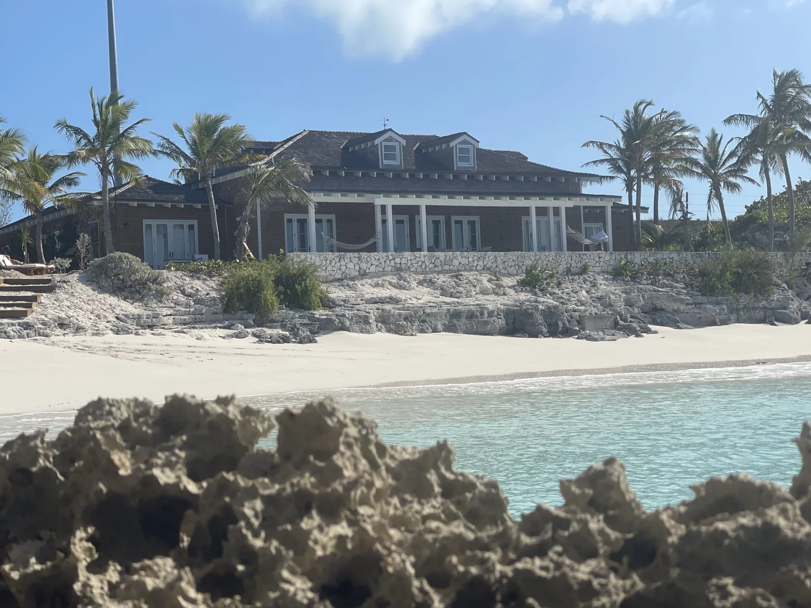 Stone-clad coastal home exterior with palms
